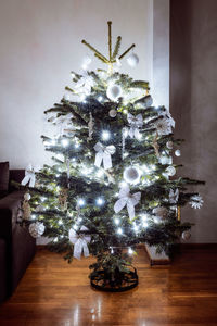 Illuminated christmas tree on floor at home