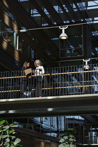 Low angle view of businesswomen communicating at office atrium
