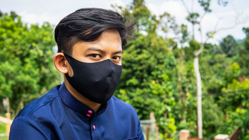 Portrait of young man against plants