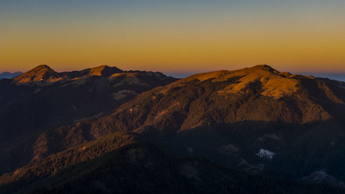 Scenic view of mountains against clear sky during sunset