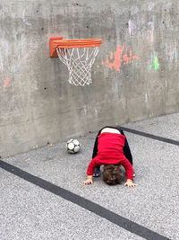 Rear view of man relaxing on basketball court
