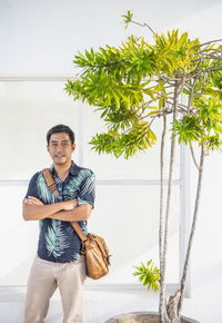 Man posing for the camera next to plotted tree in sri lanka