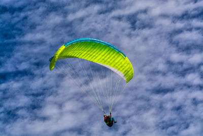 Low angle view of person paragliding against sky