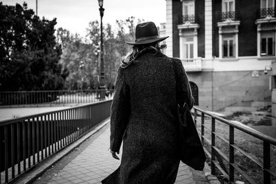 Rear view of woman walking on footpath