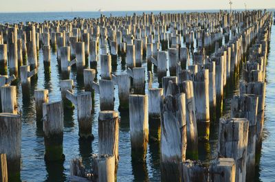 Wooden posts on beach against sky