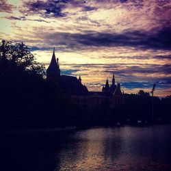 River with buildings in background against cloudy sky