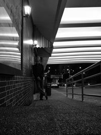 Man standing in illuminated corridor of building