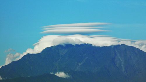 Scenic view of mountains against blue sky