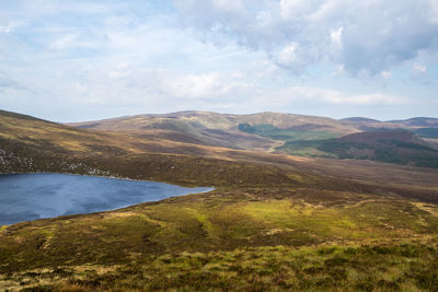 Scenic view of lake by mountains against sky