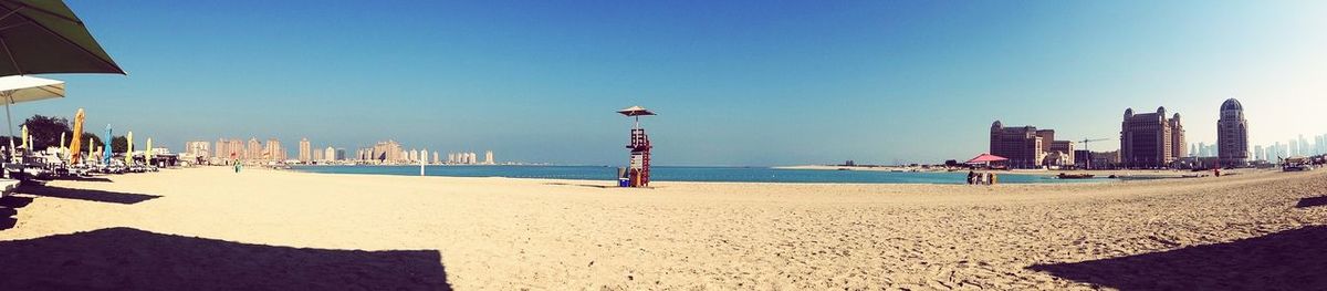 View of beach against clear blue sky