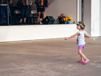 Cute girl dancing on footpath during festival