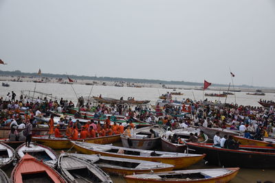 Boats moored at harbor against clear sky