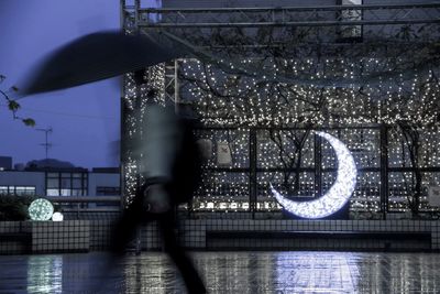 Blurred motion of illuminated ferris wheel in city