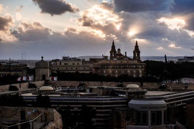 Buildings in city against cloudy sky