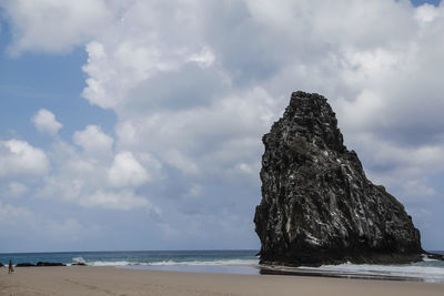 Rock formation on beach against sky