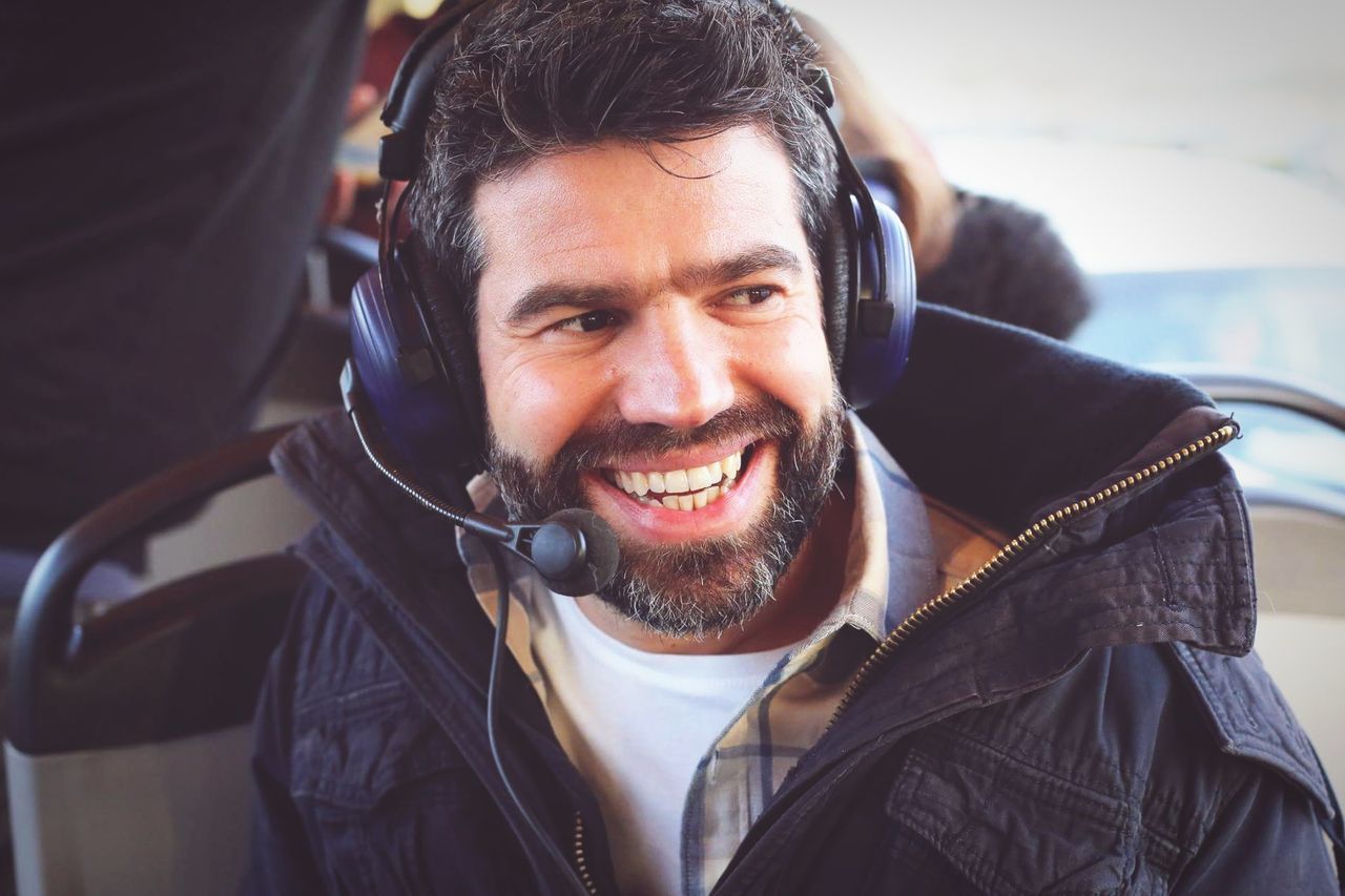 smiling, headphones, one person, happiness, portrait, real people, looking at camera, transportation, listening, cheerful, beard, music, men, indoors, day, close-up, one man only, young adult, people