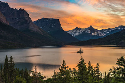 Scenic view of lake and mountains against sky at sunset