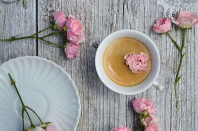 High angle view of pink flowers and cofee cup on table