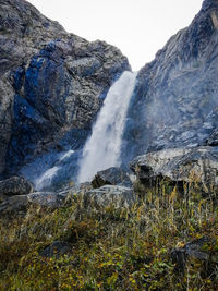 Scenic view of waterfall against sky