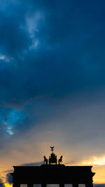 Low angle view of built structures against sky during sunset