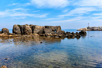 Rock formation in sea against sky