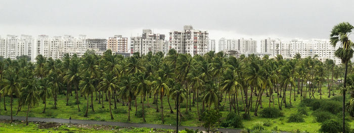 Panoramic view of field in city against sky