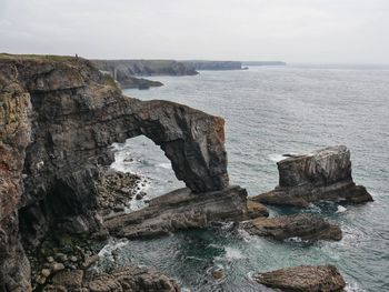 Rock formations in sea against sky