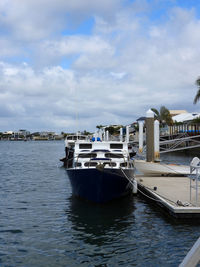 Sailboats moored at harbor