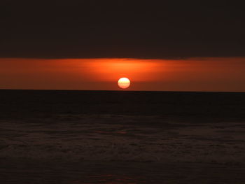 Scenic view of sea against orange sky