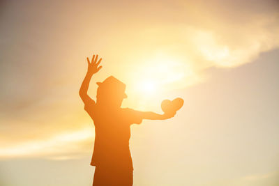 Silhouette woman standing against sky during sunset