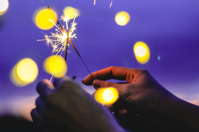 Blurred motion of person hands holding sparkler at night