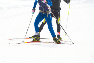 Low section of people skiing on snow