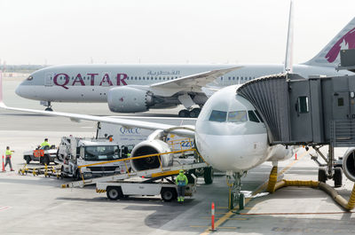 Airplane on airport runway against sky