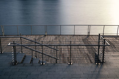 Boardwalk or walkway with modern metal fence by lake or river, long exposure photography