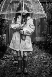 Rear view of women standing in rain during rainy season