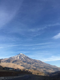 Scenic view of snowcapped mountains against blue sky