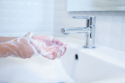 Midsection of woman in bathroom at home