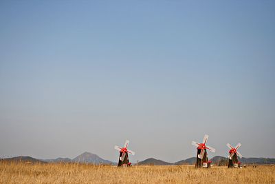 People standing on field against clear sky