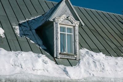 Low angle view of snow covered building against sky