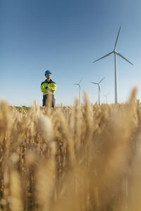 Engineer standing in a field at a wind farm