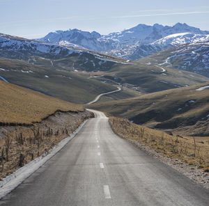 Road amidst mountains against sky