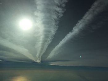 Scenic view of sea against vapor trail in sky
