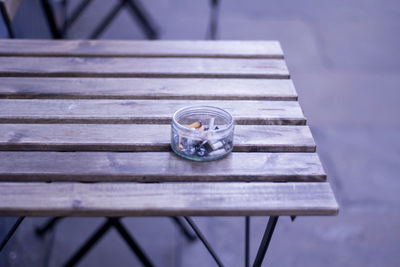 High angle view of cigarette butts in container on table at sidewalk cafe