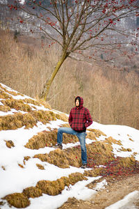 Full length of man standing by tree during winter
