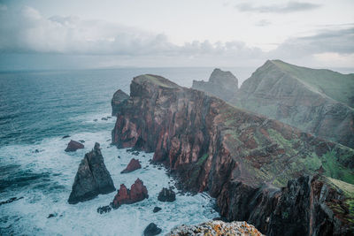 Rock formations by sea against sky