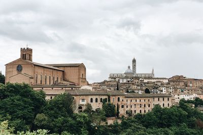 Buildings against cloudy sky in city