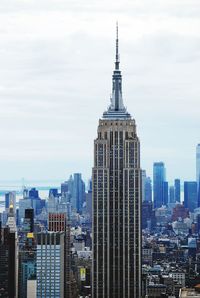 Modern buildings in city against cloudy sky