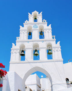 Low angle view of bell tower against clear blue sky