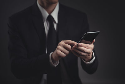 Midsection of man using mobile phone