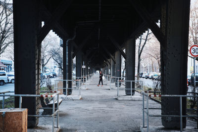 Full length of woman walking under bridge